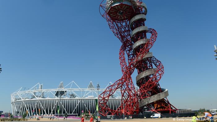 A twisted metal sculpture beside a stadium