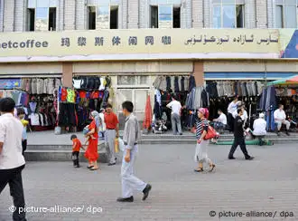 Local Chinese Uigur citizens walk past apparel shops on a street in Urumqi, northwest Chinas Xinjiang Uygur Autonomous Region, 12 July 2009. Law and order has returned to Urumqi in Chinas Xinjiang Uygur Autonomous Region after days of deadly riots earlier this month. The death toll from the riot has reportedly risen to 197. +++(c) dpa - Report+++