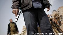 Libysche Rebellen laufen, während ein loyalistischer Kampfflugzeug überfliegt, während sie sich auf die Schlacht in Ajdabiya am 2. März 2011 vorbereiten, als Pro Moamer Kadhafi-Soldaten und Söldner, die mit Panzern und schwerer Artillerie bewaffnet sind, die nahe gelegene Stadt Brega stürmten, 200 Kilometer südwestlich der östlichen Hauptstadt Benghazi, was zu schweren Zusammenstößen führte. 