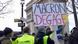 Protestor holding up anti-Macron placard Protestor holding up anti-Macron placard