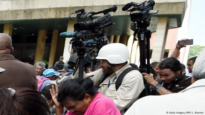 Periodistas buscan protección ante el gas lacrimógeno lanzado por la Policía en Caracas. (2016).