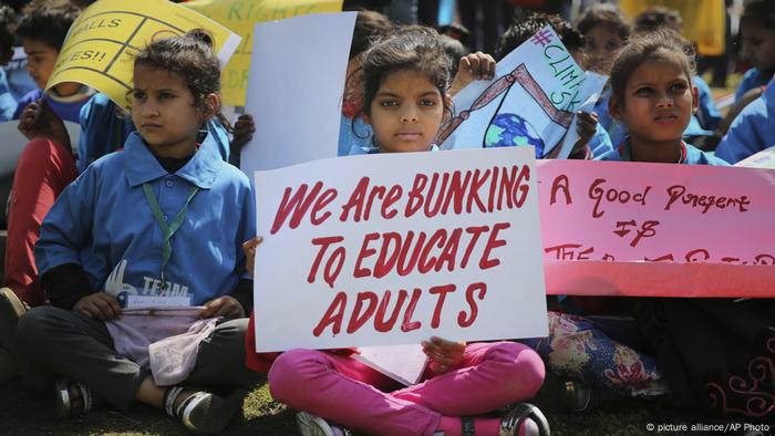 Children protesting with posters reading 'we are bunking to educate adults'