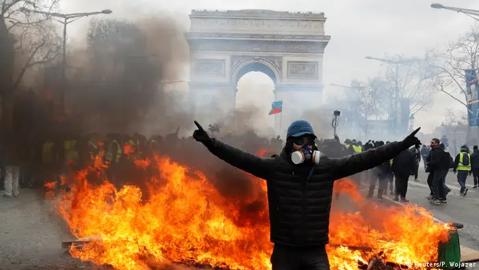 A protester stands in front of burning barricade during a demonstration by the yellow vests movement (REUTERS/Philippe Wojazer)