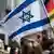 Людина в кіпі тримає прапор Ізраїлю під час демонстрації в німецькому Бонні (архівне фото) 