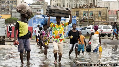 Residents of Beira walk through flooded streets with bags on their heads 