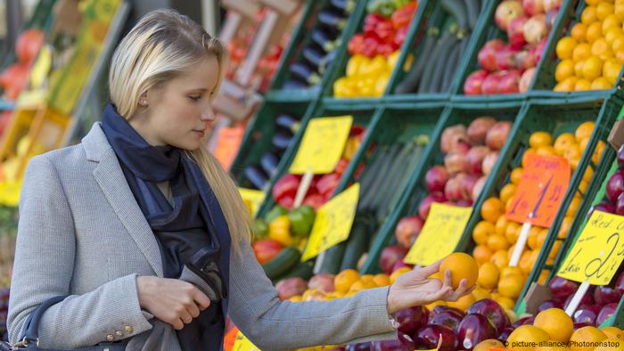 A woman buys fresh fruit at a market (picture alliance / Photononstop)