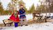 People in Finland wear traditional Sami clothing next to a sled pulled by reindeer People in Finland wear traditional Sami clothing next to a sled pulled by reindeer