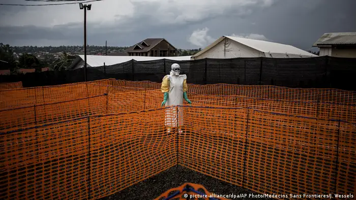 An Ebola health worker in protective clothing outside an isolation reception area