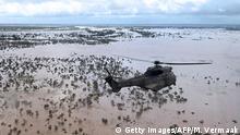TOPSHOT - An Oryx helicopter from the SANDF (South African National Defence Forces) flies during an air relief drop mission over the flooded area around Beira, central Mozambique, on March 20, 2019. - International aid agencies raced on March 20 to rescue survivors and meet spiralling humanitarian needs in three impoverished countries battered by one of the worst storms to hit southern Africa in decades. Five days after tropical cyclone Idai cut a swathe through Mozambique, Zimbabwe and Malawi, the confirmed death toll stood at more than 300 and hundreds of thousands of lives were at risk, officials said. (Photo by MARYKE VERMAAK / AFP) (Photo credit should read MARYKE VERMAAK/AFP/Getty Images)
