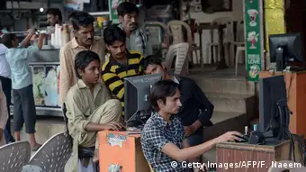 Pakistani vendors use computers to upload music and video files. Digital participation by citizens and especially marginalized groups is challenged by blasphemy and treason against political opponents (photo: Getty Images, AFP / Rarooq Naeem)