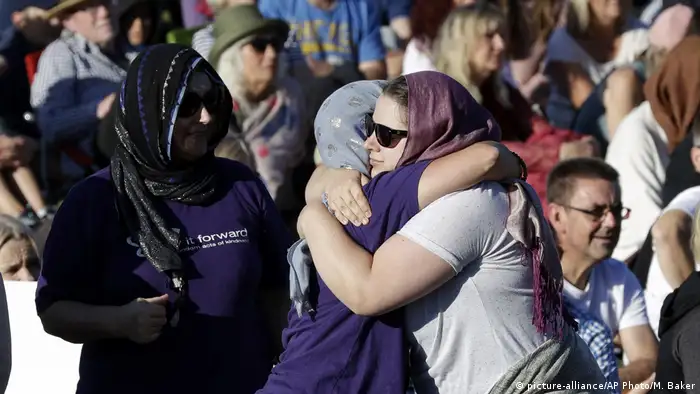 People embrace in a show of love during a vigil in Hagley Park following the March 15 mass shooting in Christchurch