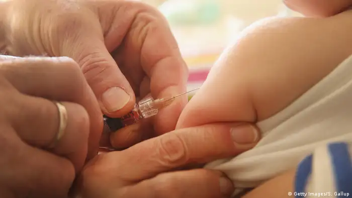 A doctor vaccinates a baby with a small needle