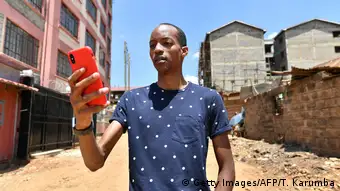 A Kenyan man holding a cellphone