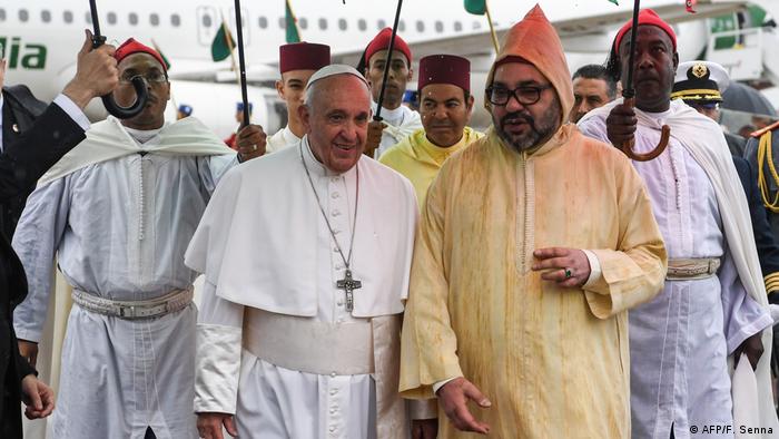 Pope Francis (center, left) is received by Morocco's King Mohammed VI (center, right) upon disembarking from his plane 