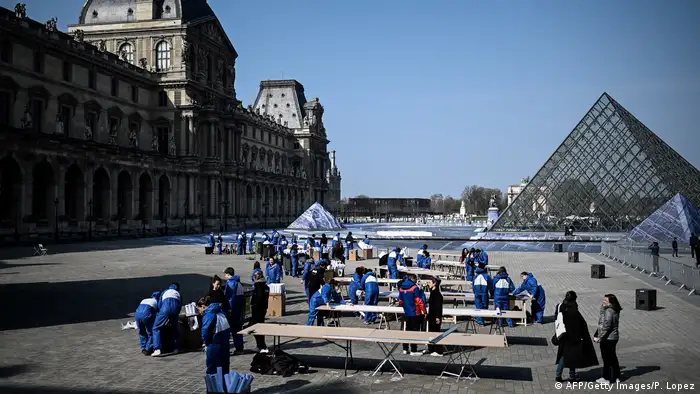 Volunteers paste strips of paper outside the Louvre, Paris