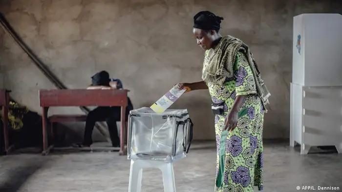 A woman deposits her ballot at a polling station