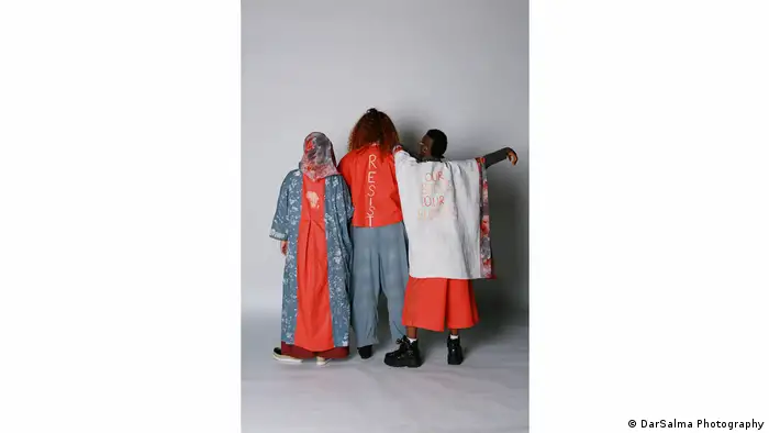 Three people turning their backs to the camera, fashion designs by Naomi Afia (DarSalma Photography)