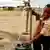 African boy pumps water at a community tap in Warrenton, South Africa