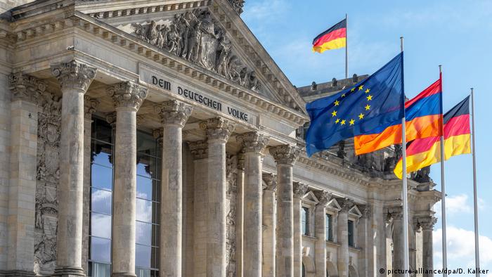 Reichstagsgebäude in Berlin mit den Flaggen von der EU, Armenien und Deutschland