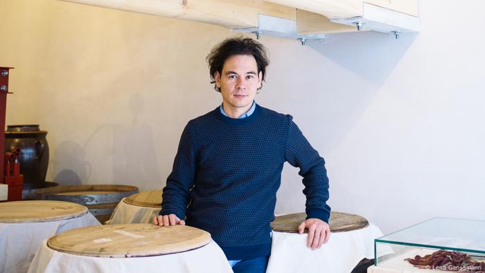 Markus Shimizu steht in seinem Geschäft Mimi Ferments neben großen Fässern. (Lena Ganssmann)
