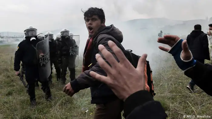Migrants shout slogans during clashes with Greek riot police outside a refugee camp in Diavata, a western suburb of Thessaloniki, where migrants gathered on April 6, 2019