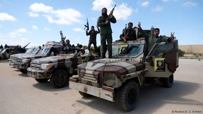 Libyan National Army (LNA) members, commanded by Khalifa Haftar, pose for a picture with their weapons as they head out of Benghazi to reinforce the troops advancing to Tripoli