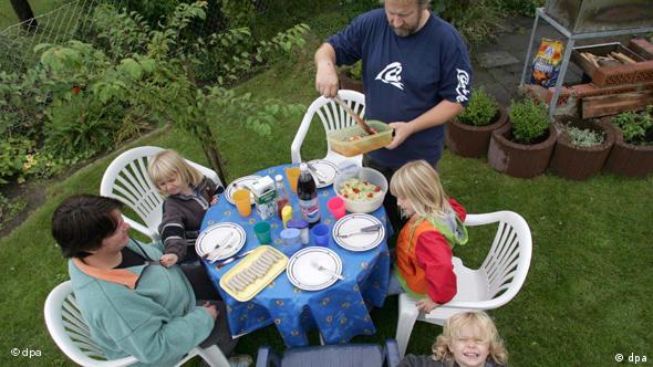 Семья в саду за обеденным столом