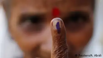 A woman show her ink-marked finger after casting her vote