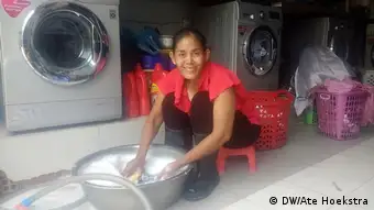 Moung San hand-washing her clothes at her laundry service