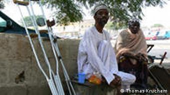 Ein Mann und eine Frau auf einer Bank. Der Mann ist in Folge von Polio behindert und muss an Krücken gehen. (Foto: Thomas Kruchem)