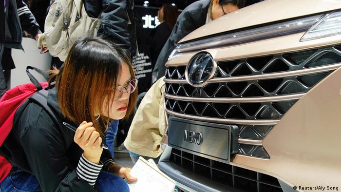 Una mujer observa la parrilla de un vehículo Hyundai. 