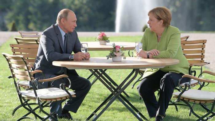 Putin at the table with Merkel