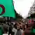 Algerians, draped in national flags, hold banners and chant slogans during an anti government demonstration in the capital Algiers, on April 19, 2019