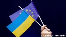 A woman holds Ukrainian and European Union flags during a policy debate of Ukraine's President and presidential candidate Petro Poroshenko with his rival, comedian Volodymyr Zelenskiy, at the National Sports Complex Olimpiyskiy stadium in Kiev, Ukraine April 19, 2019. REUTERS/Vasily Fedosenko