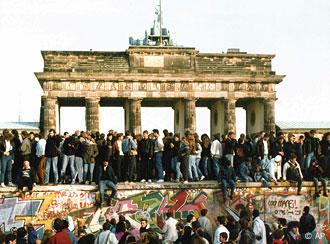 Einen Tag nach dem Fall der Mauer stehen zahlreiche Berliner auf der Mauer vor dem Brandenburger Tor