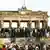 Einen Tag nach dem Fall der Mauer stehen zahlreiche Berliner auf der Mauer vor dem Brandenburger Tor