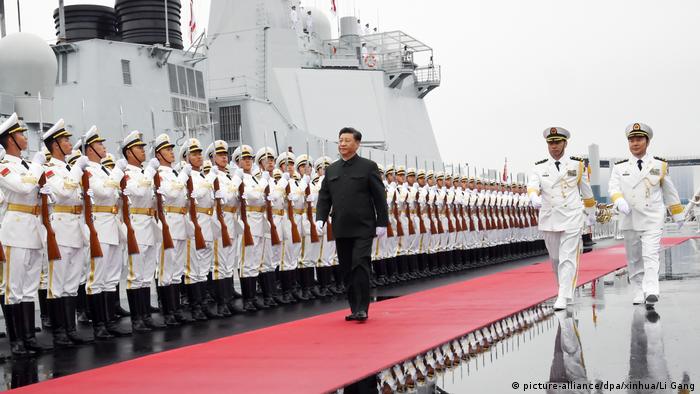 Chinese President Xi Jinping marches past Chinese naval officers at the navy's 70th anniversary