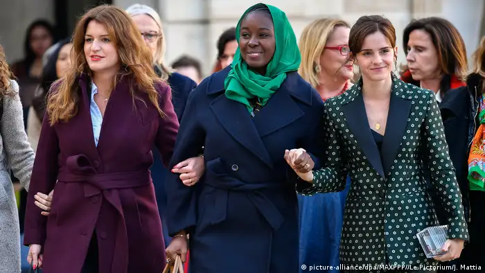 Emma Watson at right, beside two other women walking with linked hands (picturealliance/dpa/MAXPPP//Le Pictorium/J. Mattia)