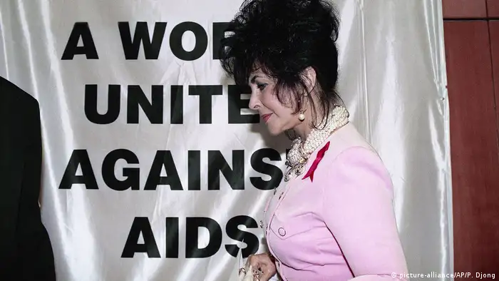Elizabeth Taylor in front of a t-shirt reading A World United Against AIDS (picture-alliance/AP/P. Djong)