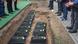 Small coffins with soldiers' remains lined up in a pit