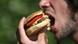 Ein Mann beißt in einen Hamburger (Foto: picturealliance) Ein Mann beißt in einen Hamburger (Foto: picturealliance)