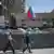 People pass under a Russian flag in front of the occupied administration building in Donetsk