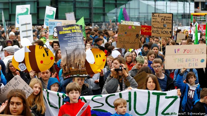 Un gran grupo de manifestantes en pro del medioambiente con pancartas en Bonn, Alemania.