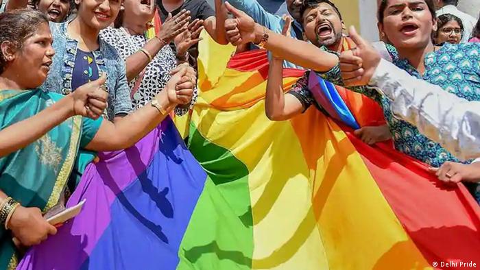 People in Delhi holding LGBTQ rainbow flag 