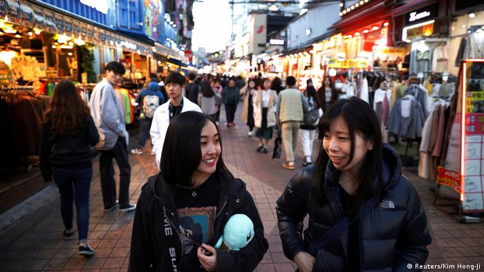 Japanese teenagers walking down a street in Seoul