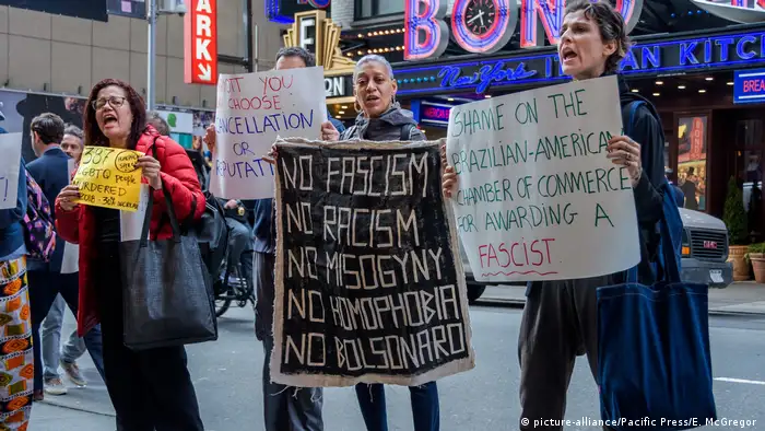 People holding up banners at an anti-Bolsonaro protest in New York