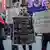 Quatro pessoas seguram cartazes contra Bolsonaro em Nova York