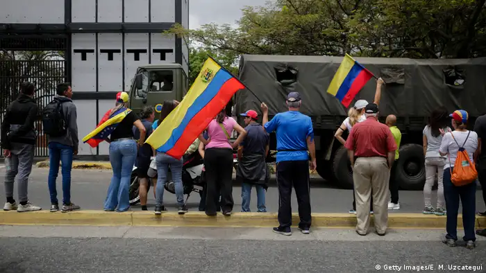Supporters of opposition leader Juan Guaido wave Venezuelan flags during a demonstration answering to Guaido's call for peaceful demonstrations to continue