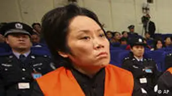 Xie Caiping, left, and other gangster suspects stand trial at the Chongqing No.5 Intermediate People's Court in Chongqing, China, Tuesday, Nov. 3, 2009. The woman called the godmother of a mafia-style gang in China's southern city of Chongqing was sentenced to 18 years in prison Tuesday for running underground casinos and bribing government officials. (AP Photo) ** CHINA OUT **