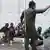 مهاجرون أفارقة في عدن ورجل أمن يراقبهم في مركز احتجاز بمدينة عدن